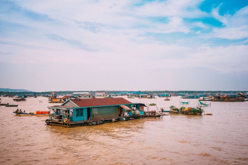 A photo of the floating village of Chong Khneas in Cambodia A photo of the floating village of Chong Khneas in Cambodia, with wooden houses on stilts and boats on the water.
