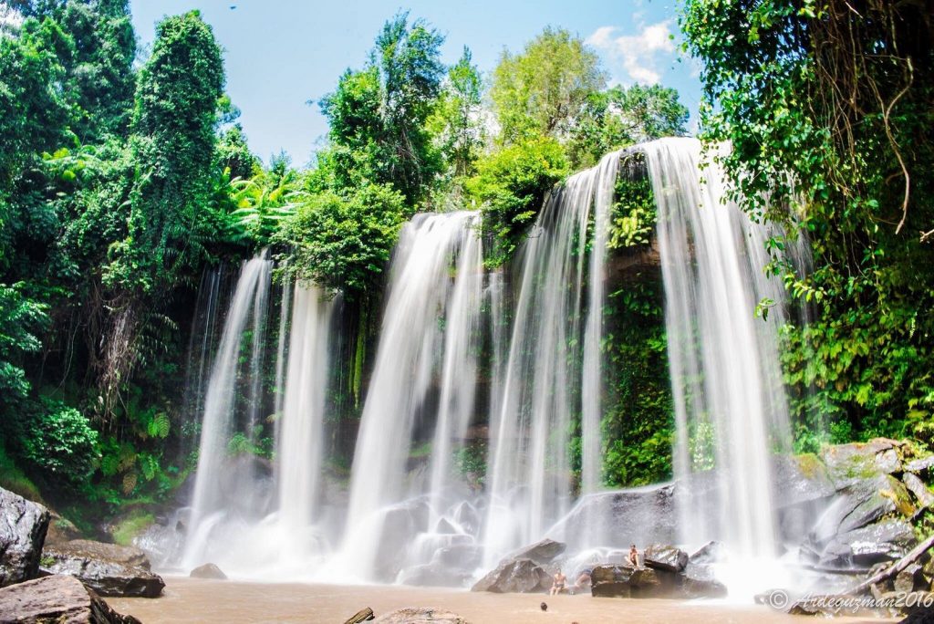 A photo of the Phnom Kulen waterfall in Cambodia, surrounded by lush greenery and rocks. A photo of the Phnom Kulen waterfall in Cambodia, surrounded by lush greenery and rocks.